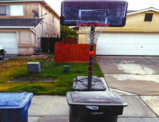 Waste bin underneath basketball hoop